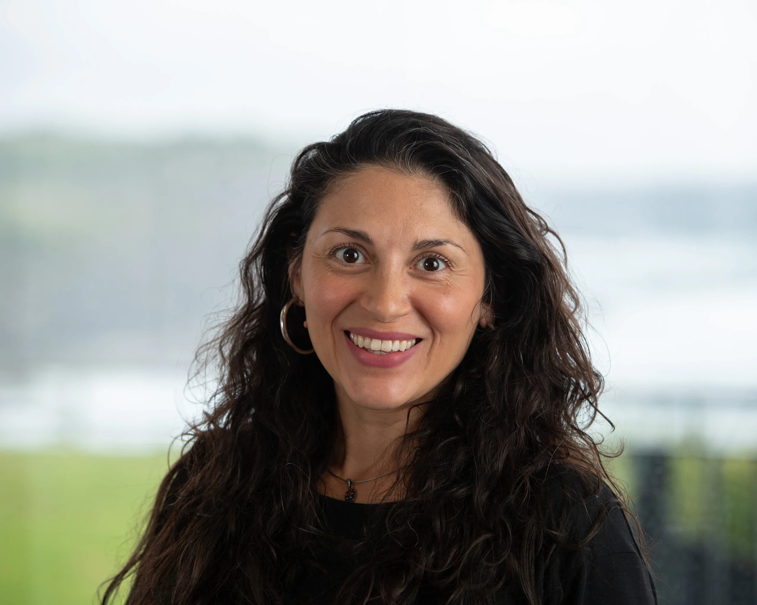 Professional head-and-shoulders portrait of Dr. Olga Lucia Gamboa Arana, wearing a black top, smiling gently against a natural background.
